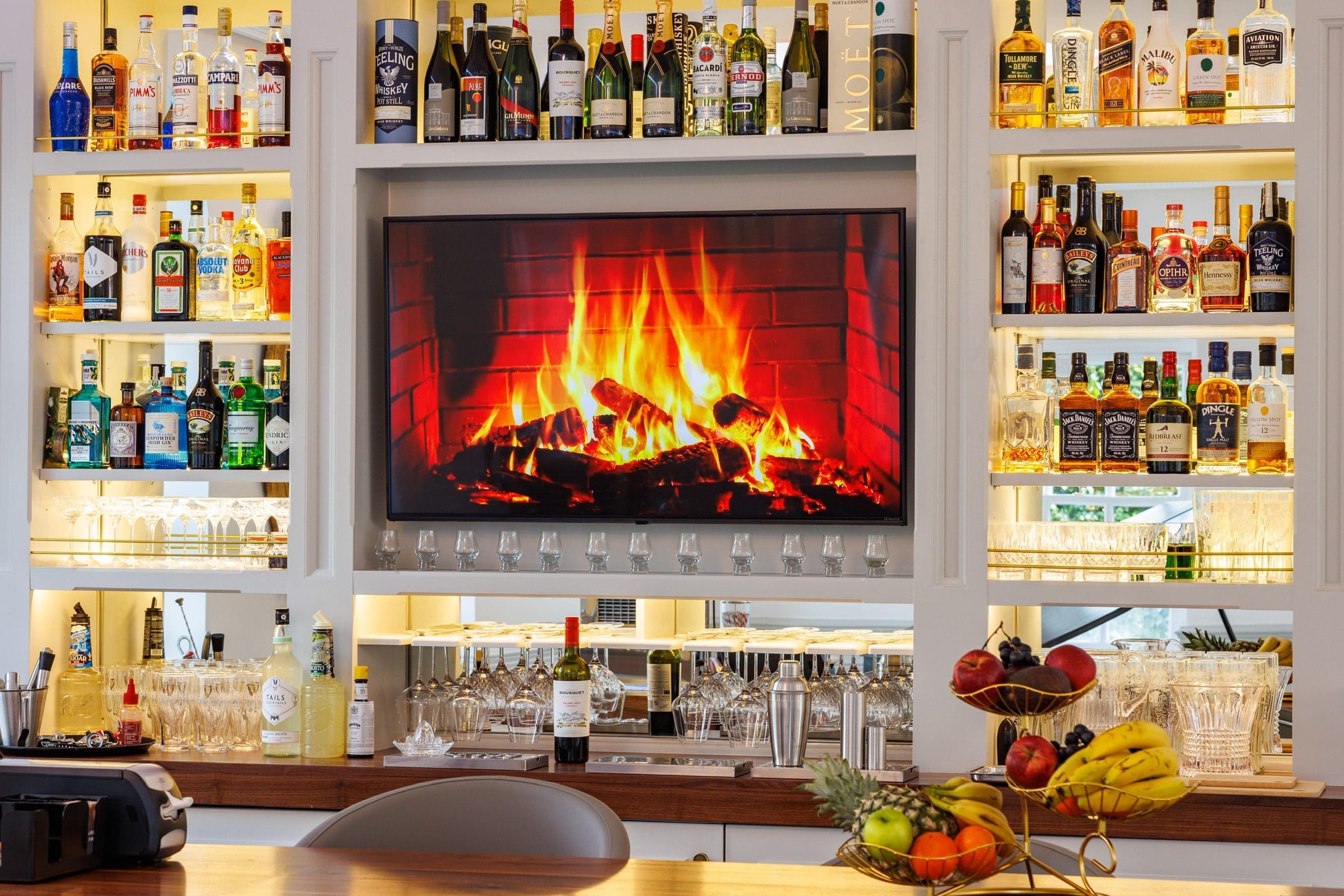 Bar at Rochtaine Mansion with a roaring fireplace projection on screen