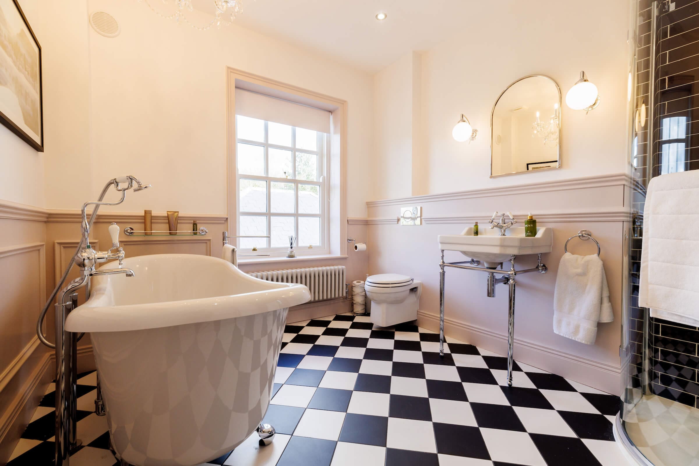 Classic bathroom suite with black and white tiles, shower, and Burlington fittings.