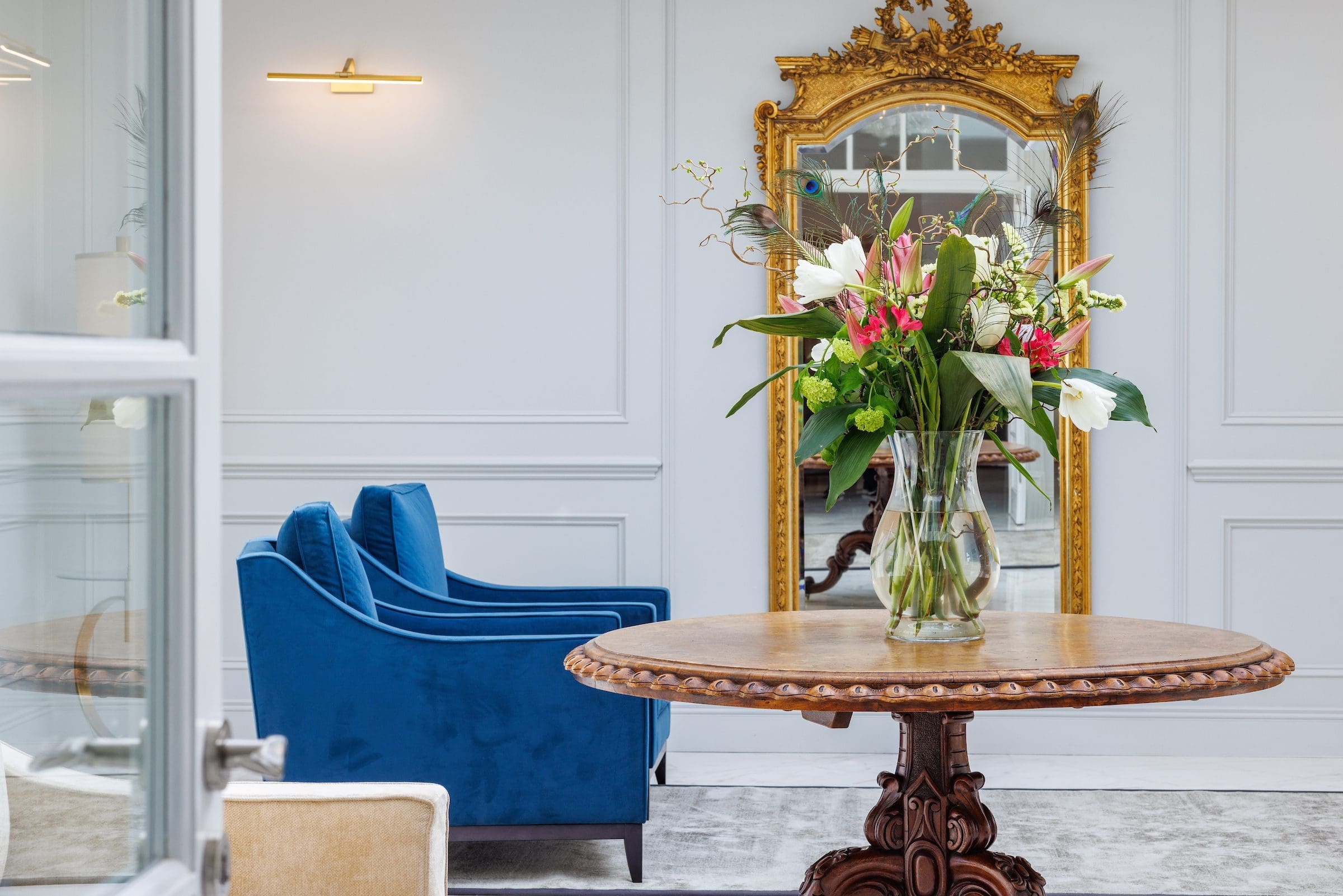Fresh flowers and a mirror in the gallery of Rochtaine Mansion.