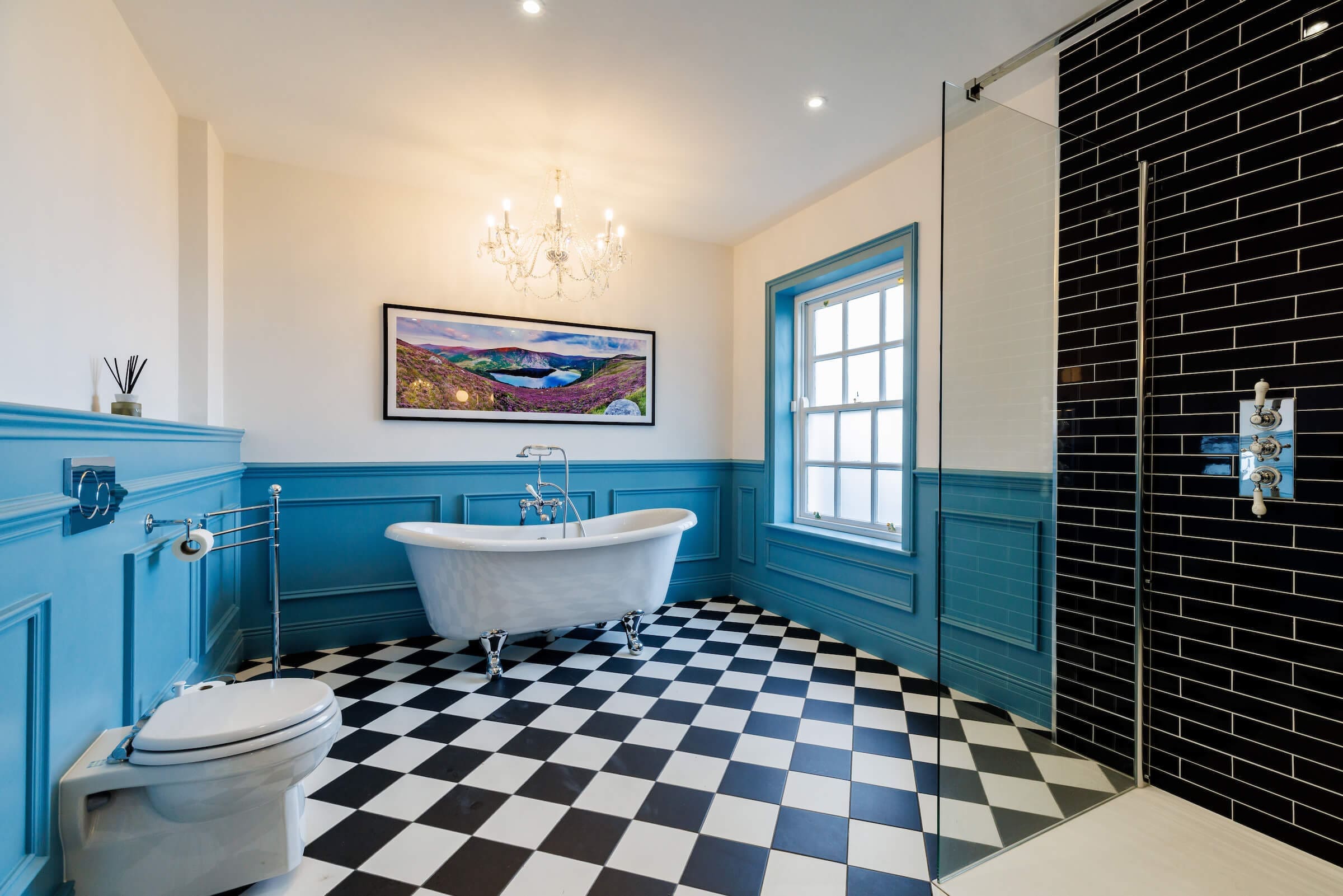 Classic bathroom suite with black and white tiles, shower, and Burlington fittings