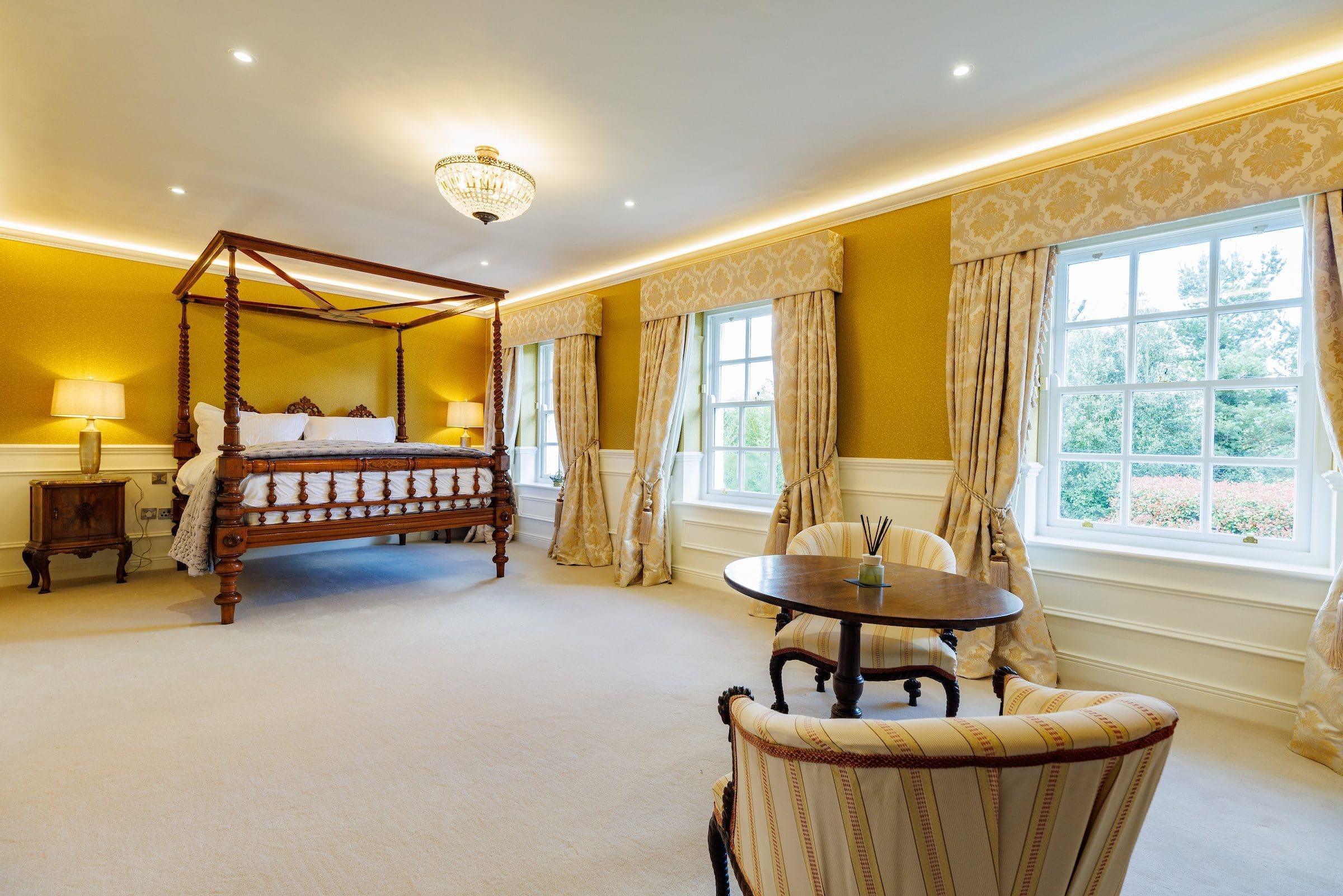 Large Victorian bed in a bedroom suite with a view of the garden.