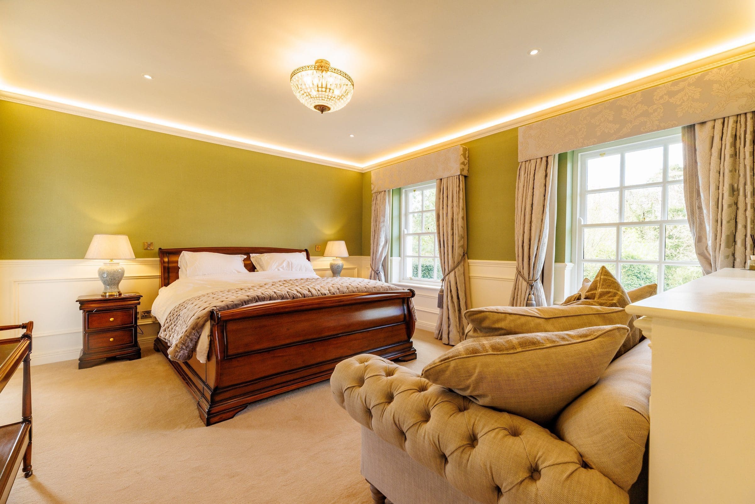 A luxurious bedroom suite with a couch and curtains in Rochtaine Mansion